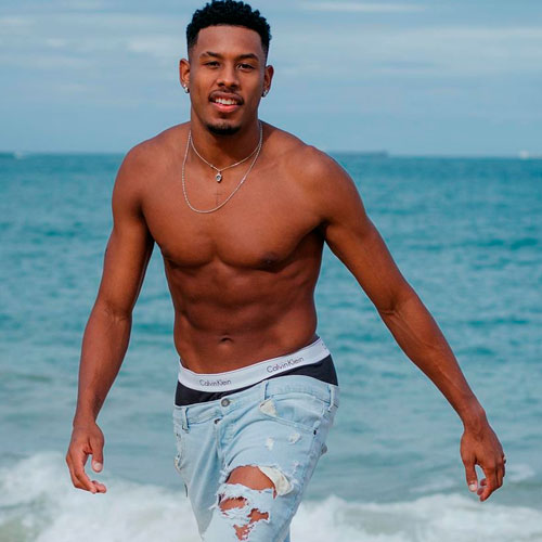 Foto do atleta Paulo André Camilo sem camisa na praia