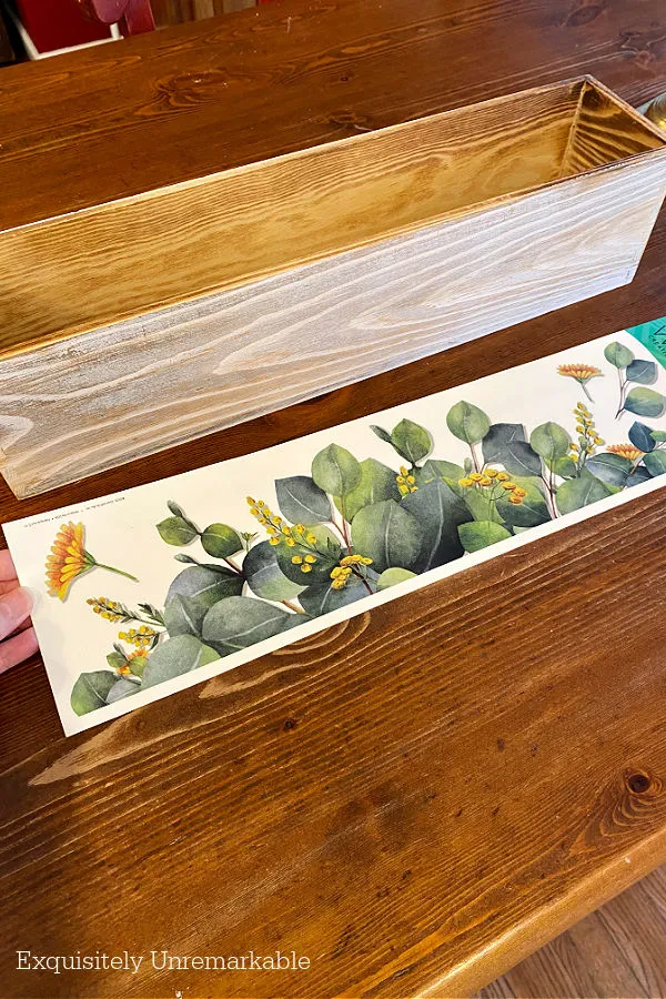 Wooden Box Planter Makeover plans using a long wooden box and wall sticker that is about the same length