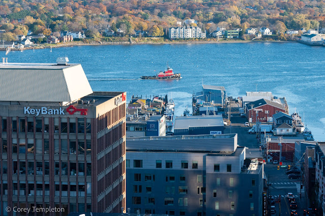 Portland, Maine October 2022 A bright red tugboat heading past the piers of Portland.