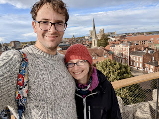 Me and John smiling for a selfie at the top of Clifford Tower with York Minster in the distance.