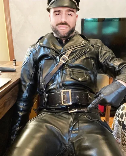Super hot leather daddy pointing to his crotch with gloves and full gear
