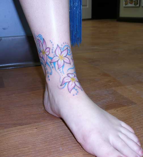 A freehand tattoo of Plumara flowers floating around the ankle Tattoos that