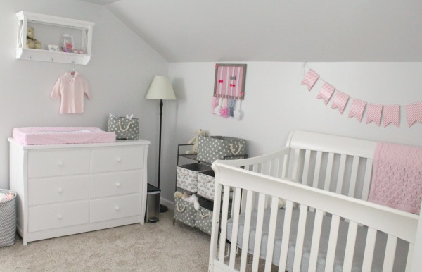 Gray white and light pink nursery for a baby girl in a small corner of a converted attic