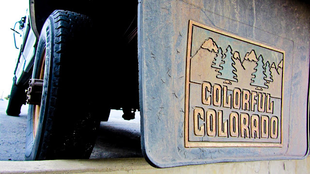 Faded and well worn Colorful Colorado mud flaps on a pickup truck in Golden, Colorado.