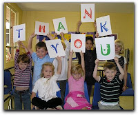 children hold thank you sign