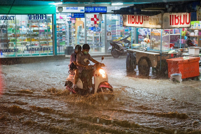 Couple riding scooter during Thailand flood