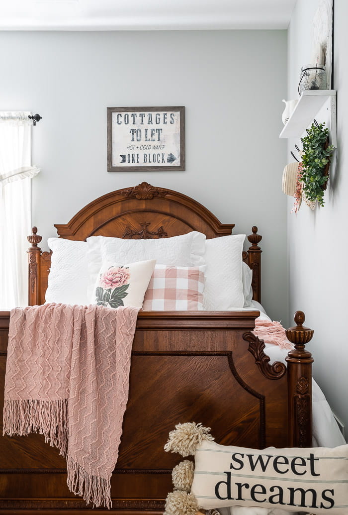 wood bed, pink throw, white bedding, floral pillows