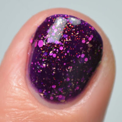 purple nail polish with pink glitter close up swatch