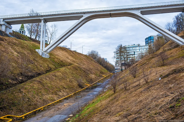 Пешеходный арочный мост над оврагом