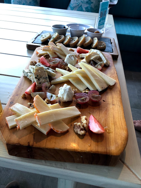 A Very Full Cheeseboard with Condiments Included