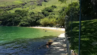 Una playa pequeña de unos 100 metros, con gente muy tranquila dentro del agua sin olas.