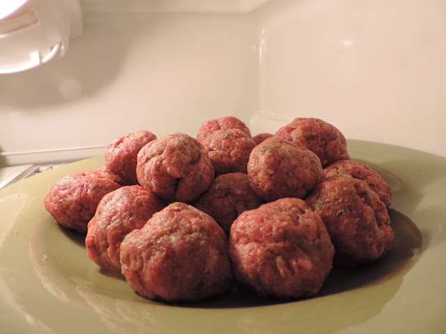 The formed meatballs on a place in the refridgerator.