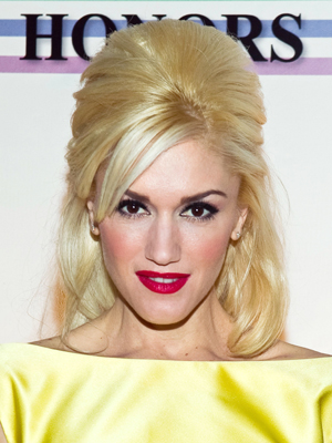 Gwen Stefani rocks a sky-high, half-up hairstyle with accenting side bangs.