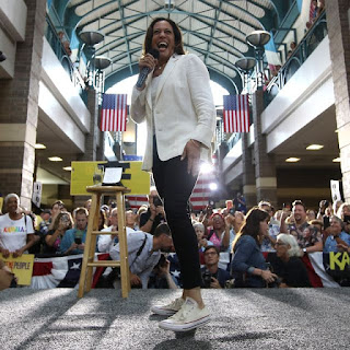 Vice President-elect Kamala Harris speaking to a large crowd sporting her Chucks