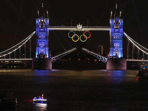 The Olympic rings hang on London's Tower Bridge as a speedboat driven by Britain's David Beckham and carrying the Olympic torch prepares to mark the opening ceremony of the 2012 Olympic Games REUTERS/PAUL HANNA 