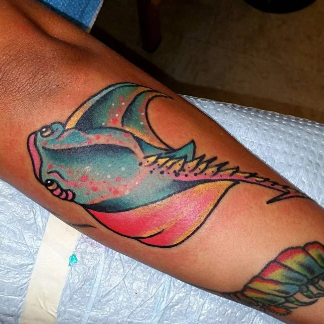 tatuaje de mantarraya a color en el antebrazo