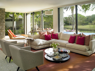 sandy hues clues this lounge area a coastal themed living room with glass walls for a gorgeous view outside