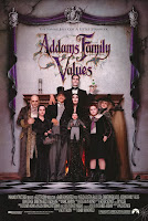 Addams Family group shot in front of an ornate fireplace