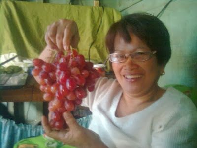 My wife displaying a bunch of grapes