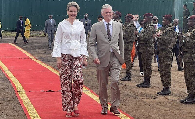 Queen Mathilde wore a white linen belted blouse and wide leg printed linen trousers from Natan. Dr. Denis Mukwege