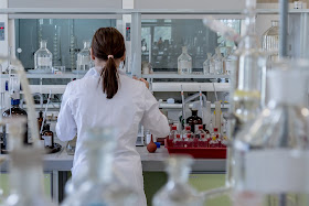 Química: Señora con bata blanca trabajando en el laboratorio de química.