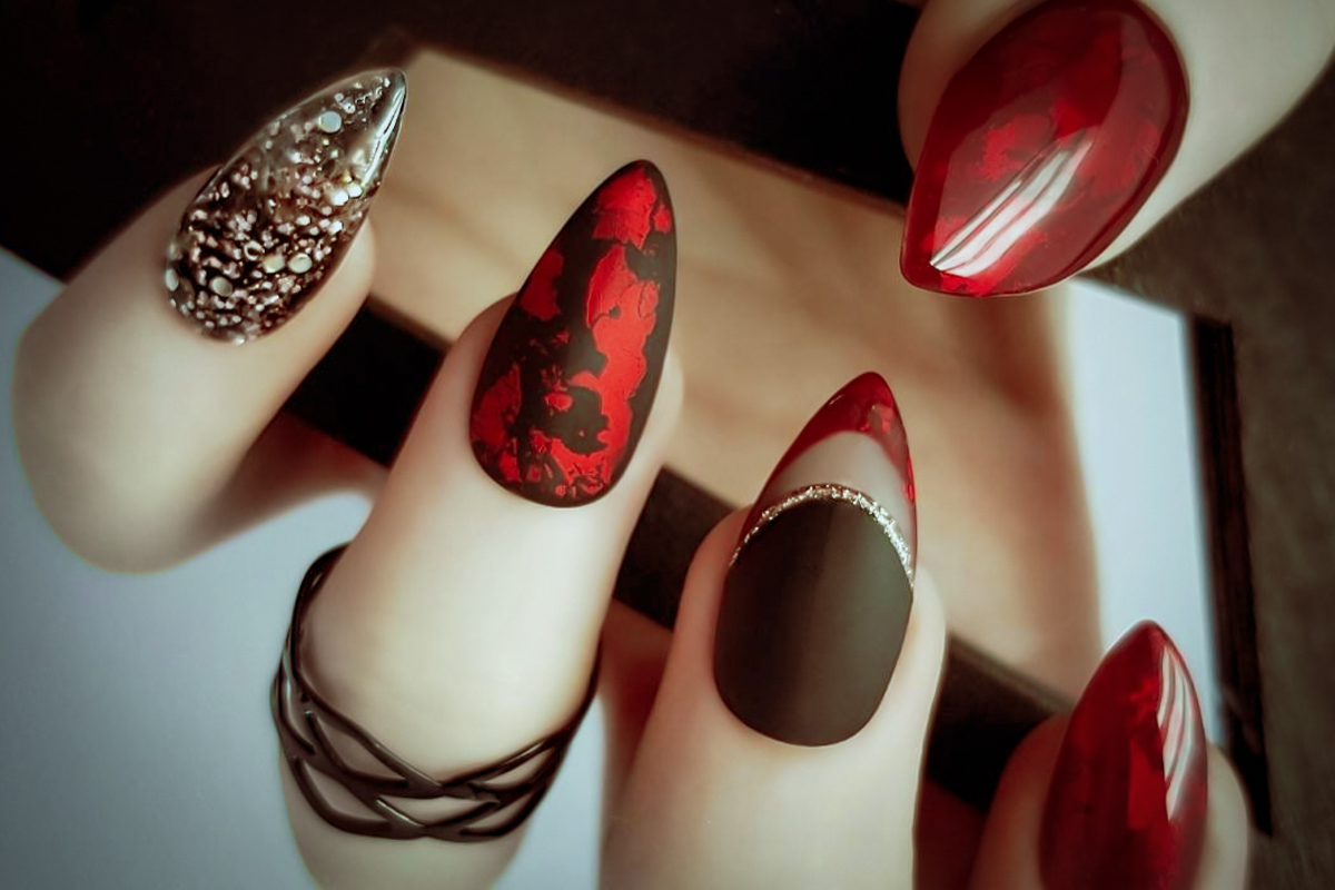 close-up of a female hand with red and black Halloween nail look