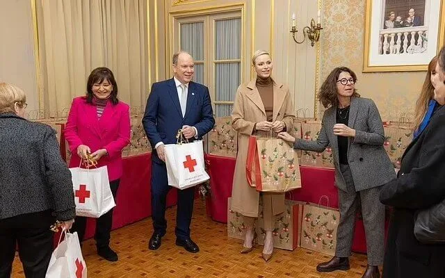 Princess Charlene wore an Emotion belted camel hair trench coat by Akris. Akris cashmere silk jersey top and Flavin wool flannel pants