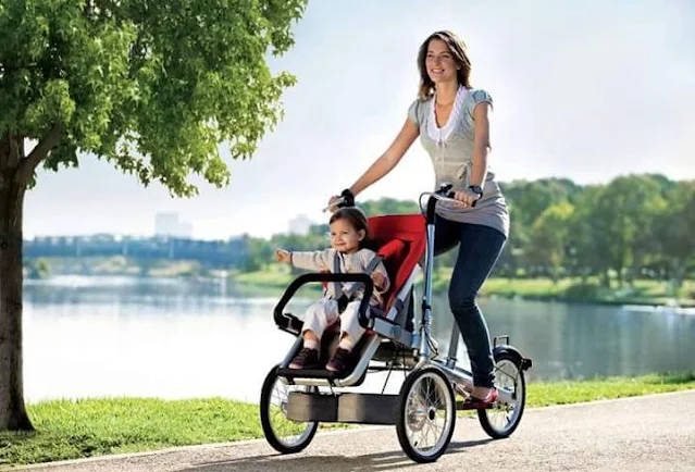 A lady riding a bicycle with her child