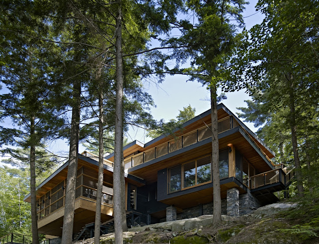 Photo of lovely forest house up on the hill between the trees