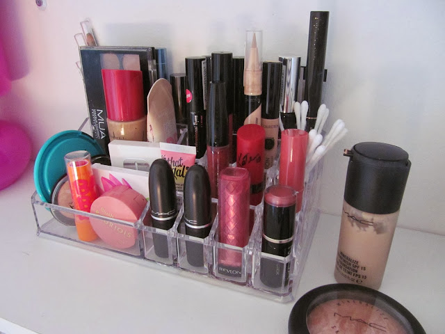 various lipsticks, palettes and powders in clear plastic organiser