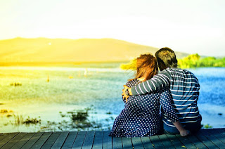 Couple assis au bord du lac