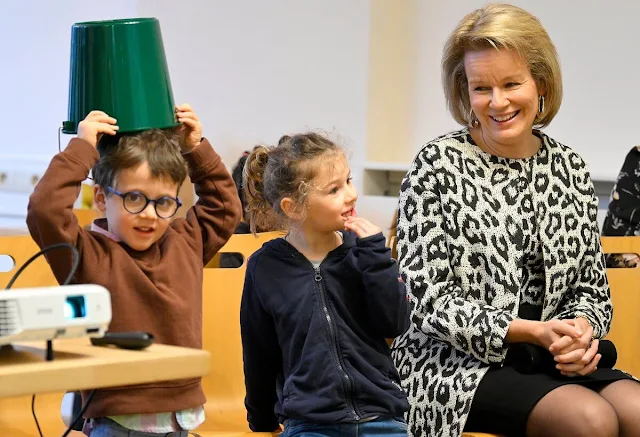 Queen Mathilde wore a white black leopard print coat and top by Armani, Natan, Maje. GoodPlanet Belgium