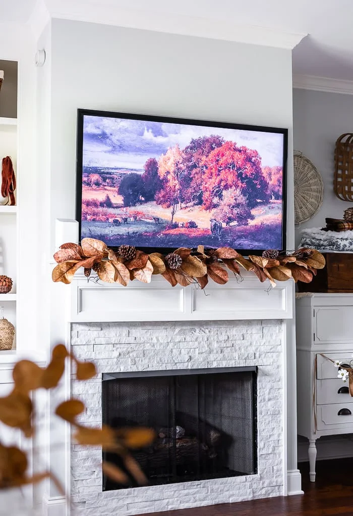 vintage tv art, large brown leaves and pinecones garland, fireplace