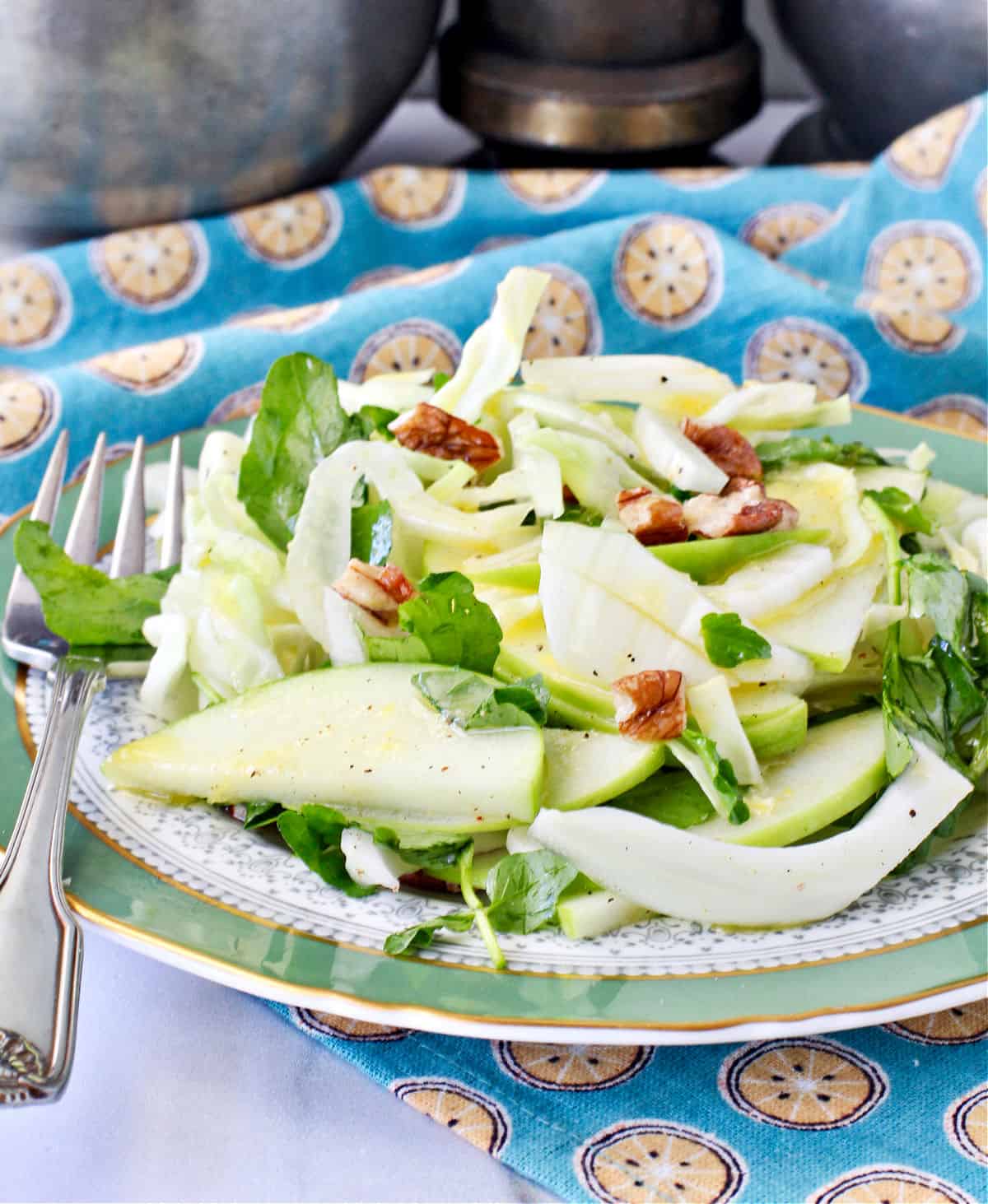 Green Cabbage and Apple Salad with Watercress and Pecans on a dinner plate.