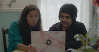 two drag kings look at a laptop