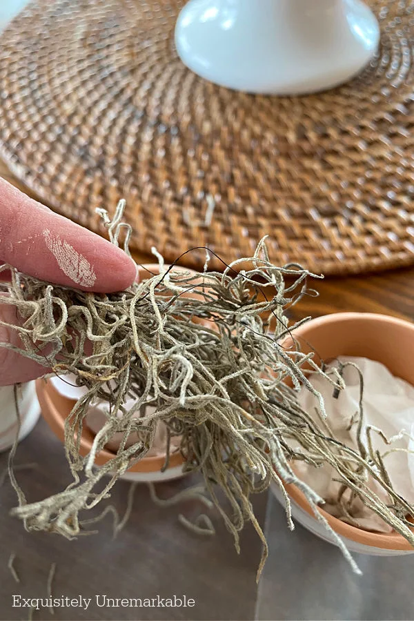 Adding moss to create a nest on a clay pot