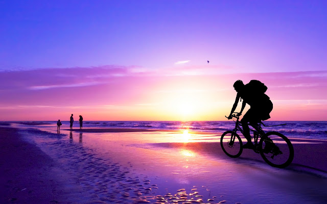 Montando Bicicleta al Atardecer en la Playa