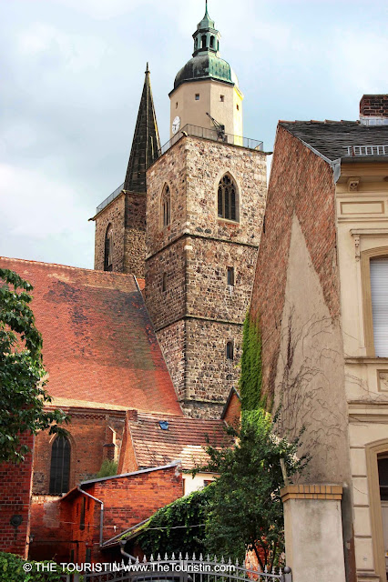 Red brick houses and a church under a broody sky.