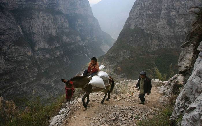 Gulu Village Primary School pupil
                                  Shen Qicai rides a donkey as his his
                                  grandfather accompanies him. Gulu is a
                                  remote Chinese mountain village
                                  located in a national park filled with
                                  canyons, sheer precipices and
                                  overhanging rocks. The village'?s
                                  primary school is probably the most
                                  remote in the world. Lying halfway up
                                  a mountain, it takes five hours to
                                  climb from the base to the
                                  school...Picture: Sipa Press / Rex
                                  Features