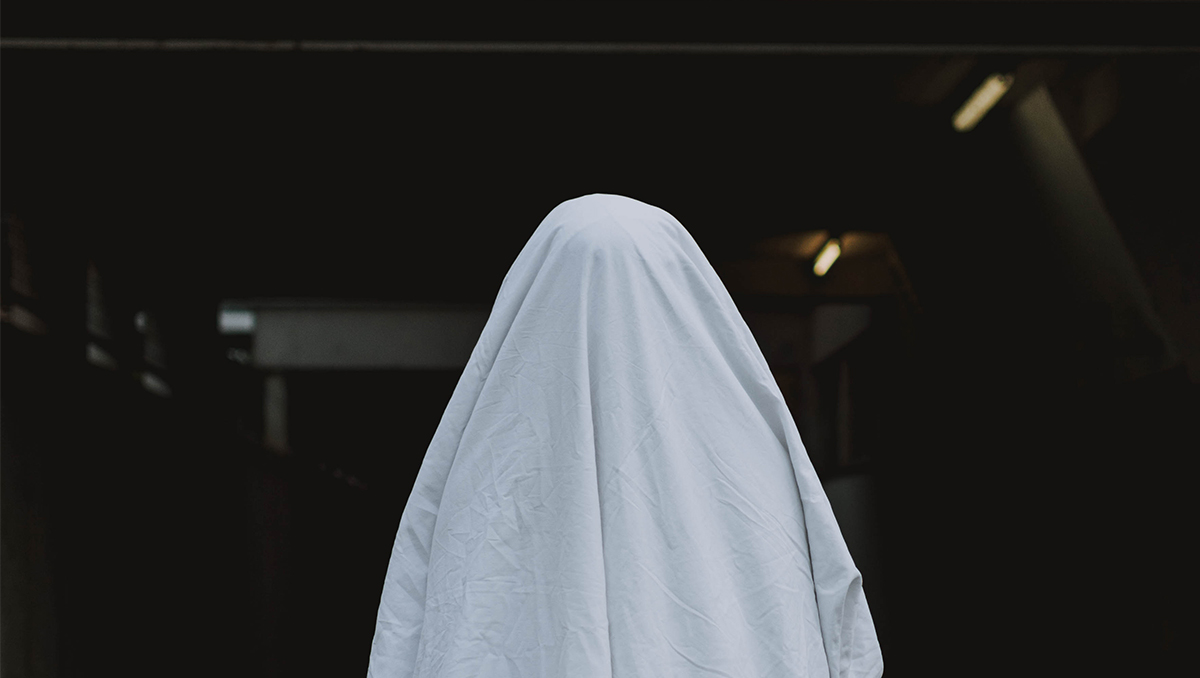 Pessoa vestida com um lençol imitando um fantasma