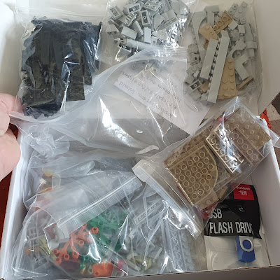 Open box showing inside contents - assorted bricks in several bags.