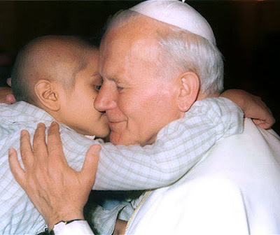 Foto de Juan Pablo II recibiendo el saludo de un niño