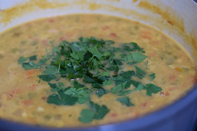 Fresh parsley being added to the vegan corn chowder.