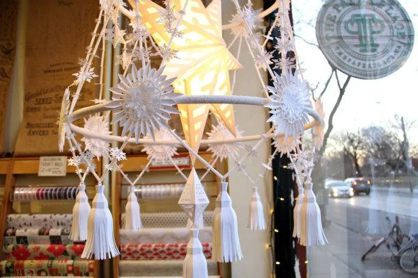 Details of a hand-constructed pajaki including white paper tassels, stars and snowflakes