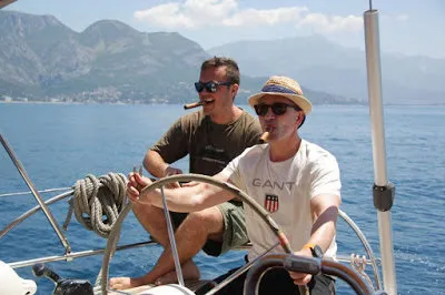 2/2 sunglasses wearing middle-aged gentleman with shirtless smoking cigars with gorgeous Blue Waters and mountains amidst