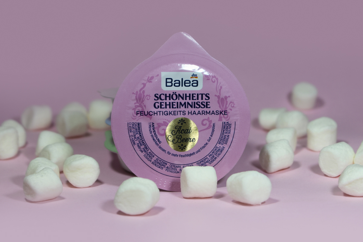 small capsule with hair care mask by balea on a pink studio's background