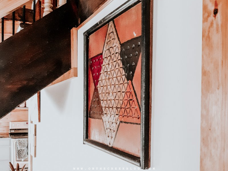 Vintage board game repurposed as rustic wall art in a log home living room | on the creek blog // www.onthecreekblog.com