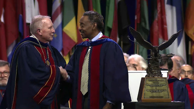 American College of Surgeons President Dr. E. Christopher Ellison presents the ACS Distinguished Lifetime Military Contribution Award to USU President Dr. Jonathan Woodson, Oct. 22, 2023.  (Screenshot photo captured by Cathy Hemelt, USU)