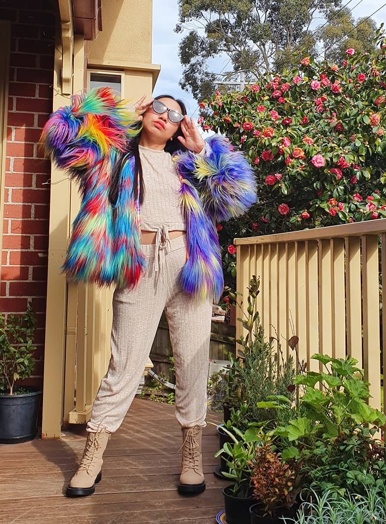 a picture of a woman wearing a colorful fake fur jacket