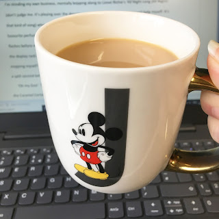 Mickey Mouse mug in front of laptop